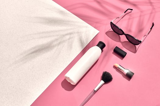 Woman's accessories lying flat on textured paper background. Pink and white pastel colors with copy space around products. photo