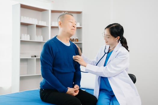 Doctor discussing treatment with Senior male patient talking and laughing sitting on examination bed in clinic or hospital photo