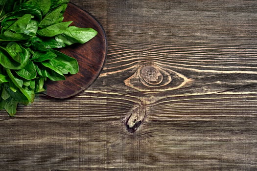 Spinach baby leaves on wooden background. Top view. Copy space photo