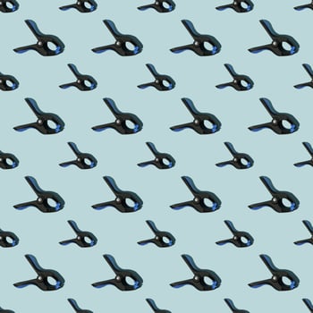Seamless pattern of black multipurpose clamps with blue grips. Blue background. photo
