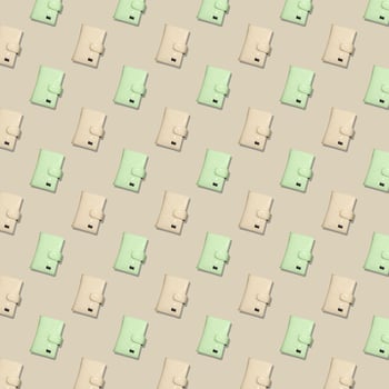 Seamless pattern of yellow and pistachio women's fashion wallets on a beige background. photo