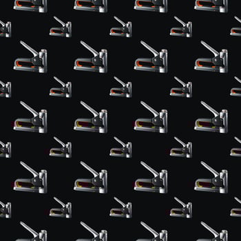 Seamless pattern of construction staplers on a black background. Background for the design. photo