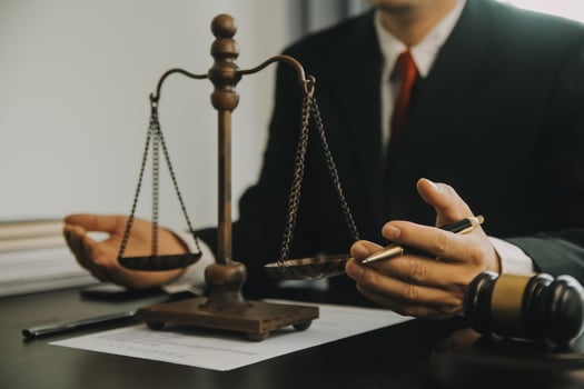 Justice and Law concept. Legal counsel presents to the client a signed contract with gavel and legal law or legal having team meeting at law firm in background photo
