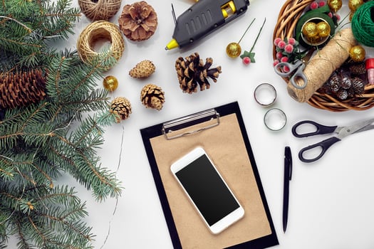 Preparing for Christmas or New Year holiday. Flat-lay of fur tree branches, wreaths, rope, scissors, craft paper over white table background, top view. photo