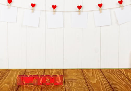 white pieces of paper on clothespins with a heart on a wooden background, a wooden inscription I love you photo