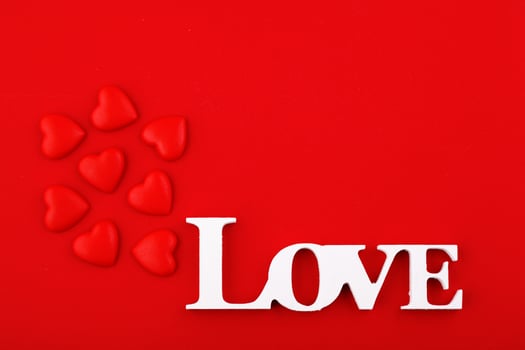 inscription love and red hearts on a red background photo