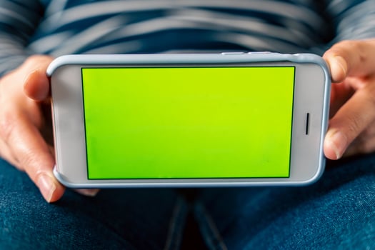 Close-up of woman holding and showing mobile phone with blank screen mockup photo