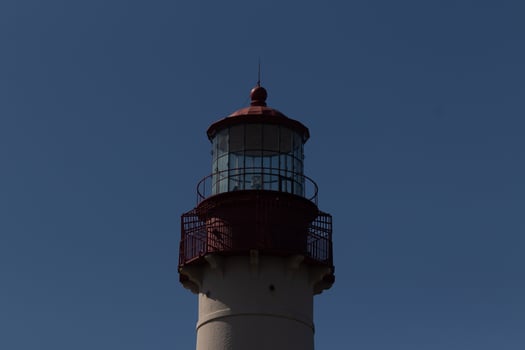 This is the top image of Capy May point lighthouse. The red metal top stands out against the white brick of the tower. photo