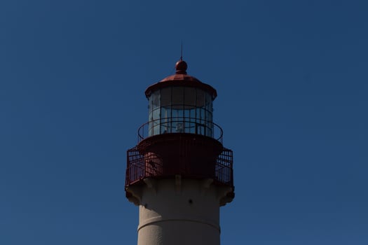 This is the top image of Capy May point lighthouse. The red metal top stands out against the white brick of the tower. photo
