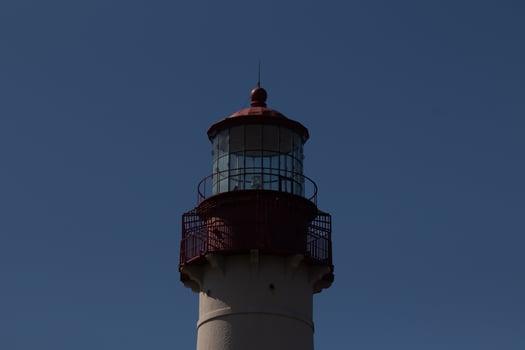 This is the top image of Capy May point lighthouse. The red metal top stands out against the white brick of the tower. photo