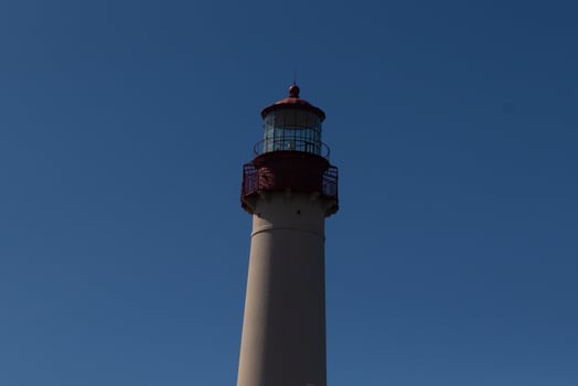 This is the top image of Capy May point lighthouse. The red metal top stands out against the white brick of the tower. photo