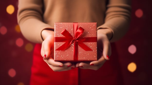 Woman with a gift box bind with ribbon in a clean red backdrop, Generative AI. photo