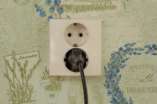 Two pin wall socket with double holes with plug in it photo