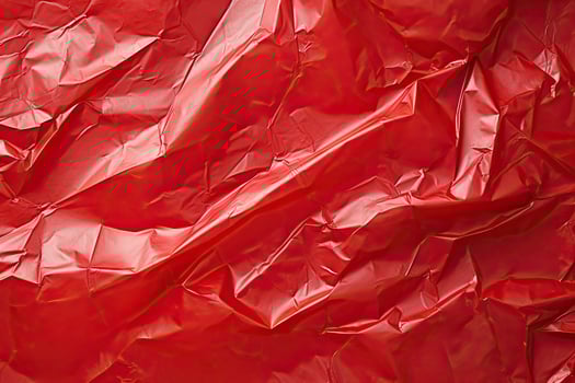 red plastic wrap overlay backdrop. crumpled and draped textured cellophane material photo