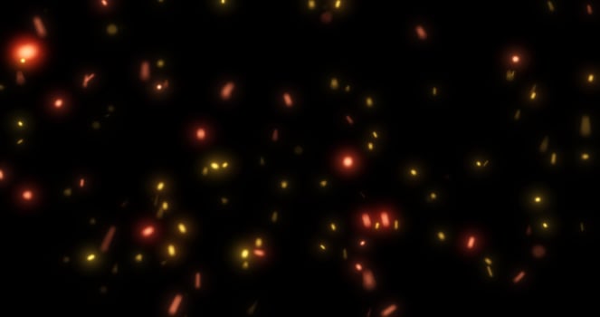 Abstract bright background of flying yellow glowing orange fire sparks from a fire on a black background photo