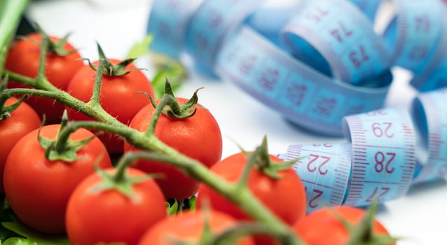 Measuring tape and fresh vegetables on the table. Healthy food concept. Close-up. Selective focus. photo