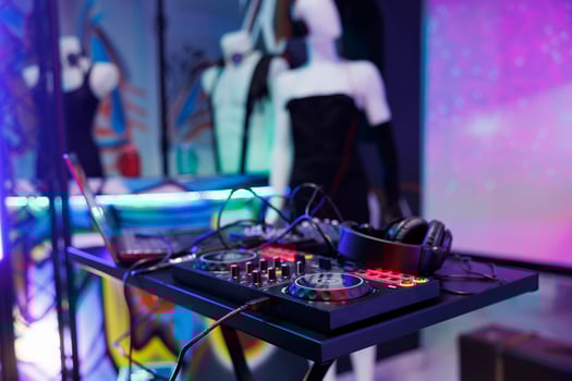 Dj controller for electronic music concert at dark club stage with spotlight glow. Musician console panel for sound mixing and headphones for live performance in nightclub close up photo