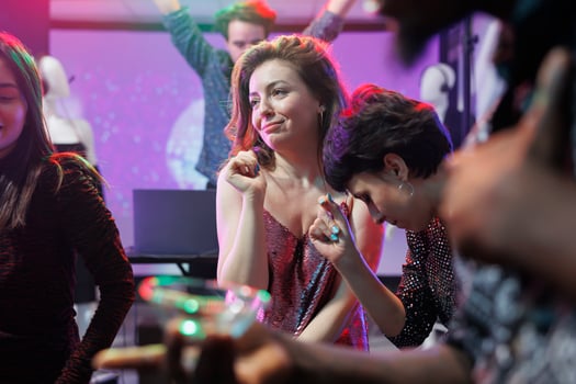 Smiling women partying and having fun at nightclub disco social gathering. Carefree caucasian young girlfriends laughing, celebrating and relaxing at club night discotheque photo
