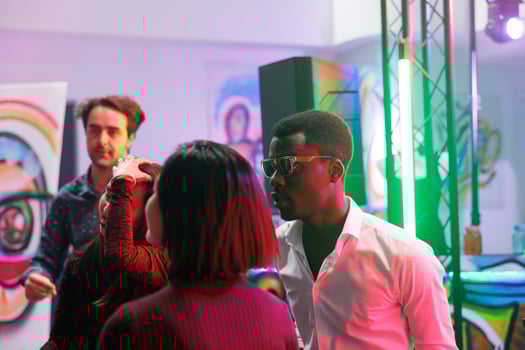 Young people partying at nightclub discotheque, celebrating and enjoying nightlife entertainment. Men and women clubbing, dancing and moving to techno music rhythm on dancefloor photo