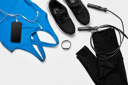 Sport, fitness, healthy lifestyle, cardio training and objects concept - close up of female sports clothing, skipping rope and bottle set photo