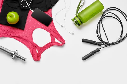 Sport, fitness, healthy lifestyle, cardio training and objects concept - close up of female sports clothing, skipping rope and bottle set photo
