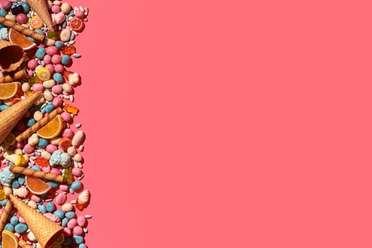Various sweets, candys are palced on the photo on the coral background