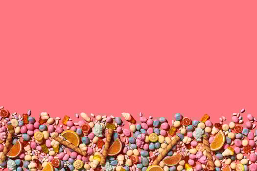 Various sweets, candys are palced on the photo on the coral background