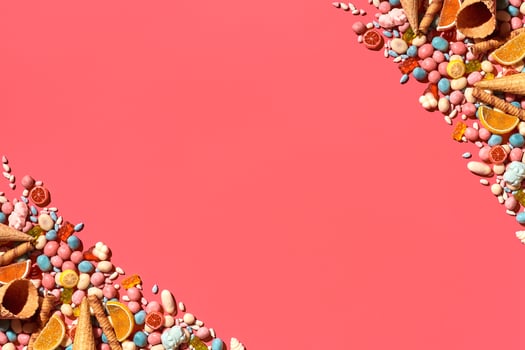 Various sweets, candys are palced on the photo on the coral background