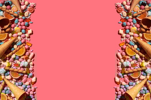 Various sweets, candys are palced on the photo on the coral background