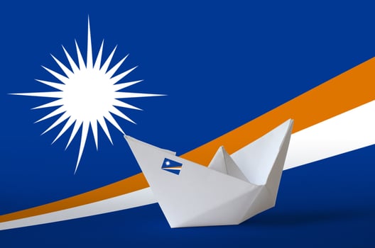 Marshall Islands flag depicted on paper origami ship closeup. Handmade arts concept photo
