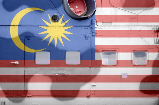 Malaysia flag depicted on side part of military armored helicopter closeup. Army forces aircraft conceptual background photo