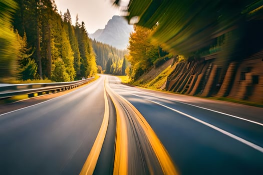 a blurry image of a road with trees and mountains. AI-Generated photo