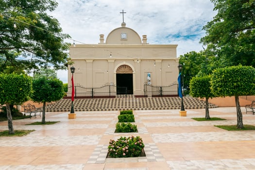 Beautiful church in a park with a garden and trees. Nagarote Park Catholic Church. Nicaragua, View of a church in a beautiful central park on a sunny day. photo