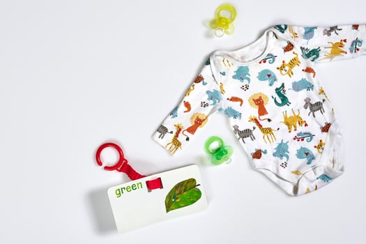 Baby care accessories and clothing on white background, top view photo