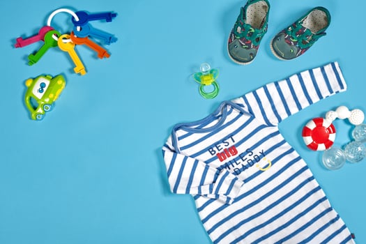 Baby clothing, toiletries, toys and health care accessories on blue background. photo