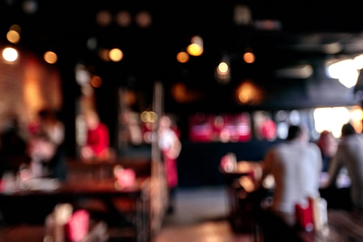 Blurred restaurant or cafe background. Tables and chairs in the lobby of the mall. Visitors to the restaurant for dinner. Beautiful bright interior. photo