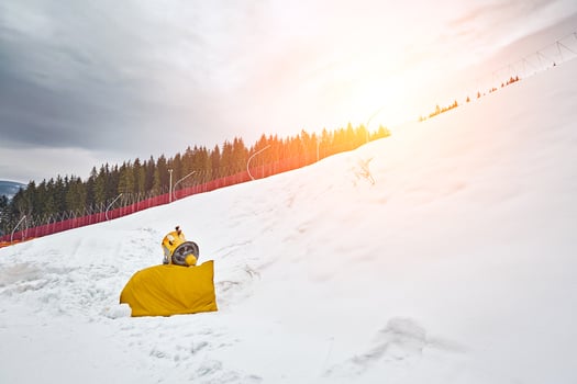 Panorama of ski resort, slope, people on the ski lift, skiers on the piste among green pine trees and snow lances. photo