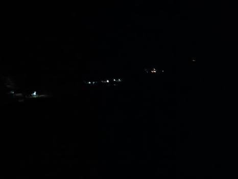 fir trees on meadow between hillsides with conifer forest in fog under the blue sky at night. spooky countryside scenery in full moon light photo