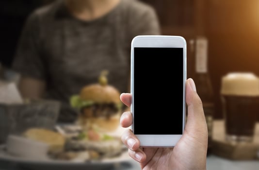 Man's hand shows mobile smartphone in vertical position photo