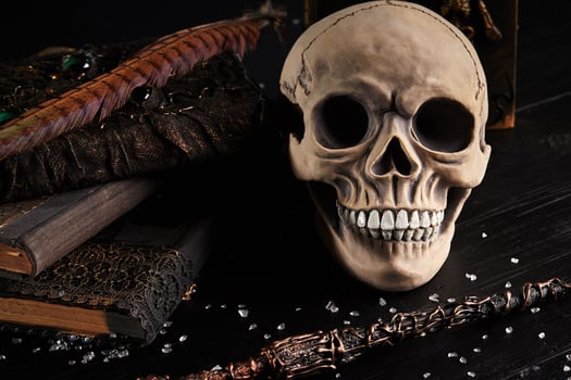 Realistic model of a human skull with teeth on a wooden dark table, black background. Medical science or Halloween horror concept. Close-up shot. photo