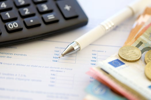 Filling french tax form process with calculator, pen and euro money bills close up. Tax paying period photo