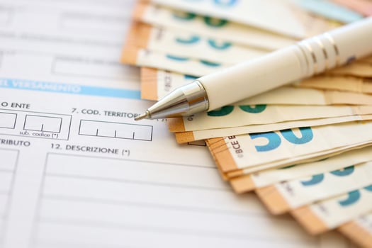 Filling italian tax form process with pen and euro money bills close up. Tax paying period photo