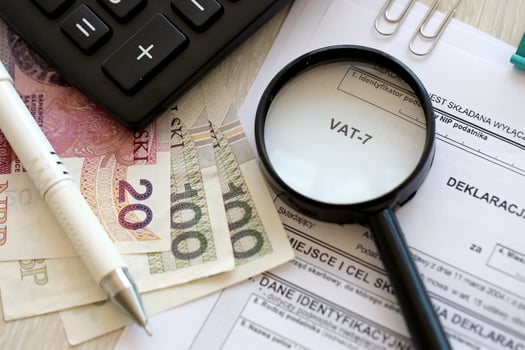 Declaration for tax on goods and services VAT-7 form on accountant table with pen and polish zloty money bills photo