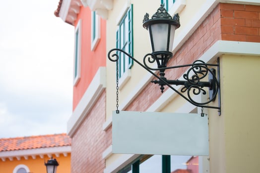 Outdoor decorative wall lamp attached to a pastel-colored building facade, capturing European architectural charm under soft daylight, ideal for travel and architecture concepts. photo
