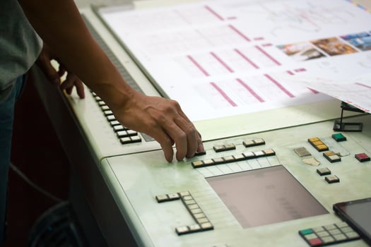 Worker operating industrial control panel with buttons and switches, concept of manufacturing, production, and factory technology. photo