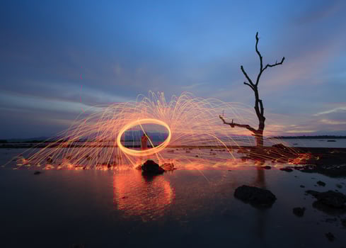 A man is standing in the water with a spinning wheel photo