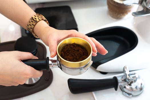 The process of making coffee step by step. Women tamping freshly ground coffee beans in a portafilter. A coffee roaster checking a coffee sample from a coffee roaster machine. photo