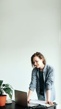 Young Businesswoman Working on Laptop at Office. Student Girl Embracing Productivity in Modern Workspace. Freelance, Business Casual, and Vibrant Lifestyle Concept. photo