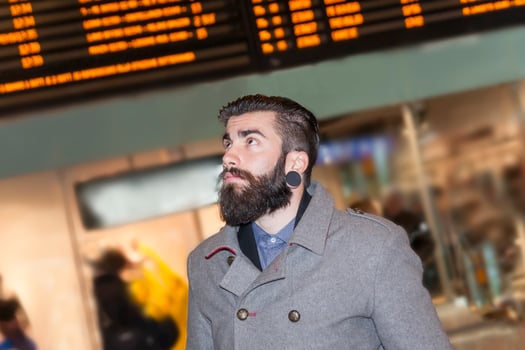 hipster businessman consult the board of timetable trains photo