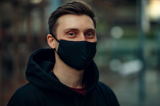 A guy in a medical mask walks down the street photo